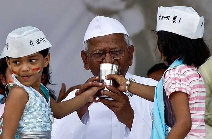 Anna Hazare, 74 ára, fær hér hjálp tveggja stúlkna við að taka langþráðan sopa.