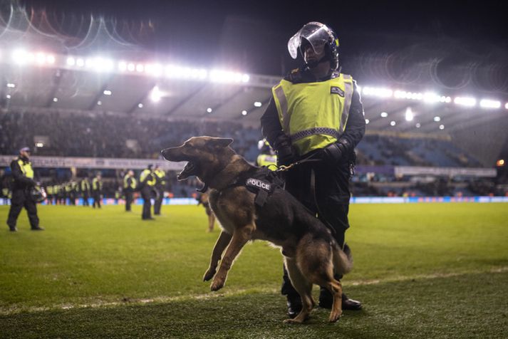 Lögreglumaður með hund á The Den á laugardaginn.