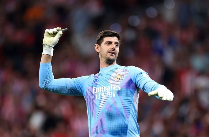 Thibaut Courtois kastar kveikjara út af vellinum í gær.