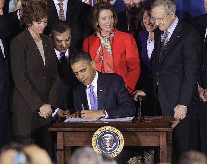 Barack Obama undirritar lögin að viðstöddum leiðtogum demókrata á þingi, þeim Nancy Pelosi og Harry Reed.fréttablaðið/AP