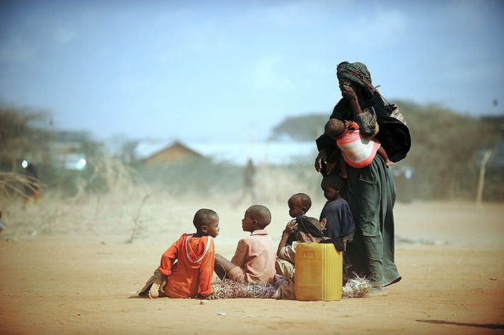 Móðir bíður eftir matargjöf ásamt börnum sínum fyrir utan Dadaab flóttamannabúðirnar í Kenya.