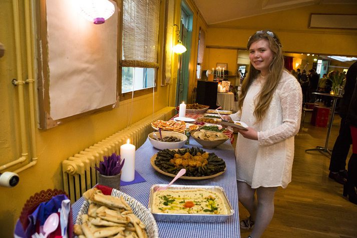 Áróra Elí Vigdísardóttir stendur yfir veisluborði sem svignar undan sýrlenskum kræsingum.