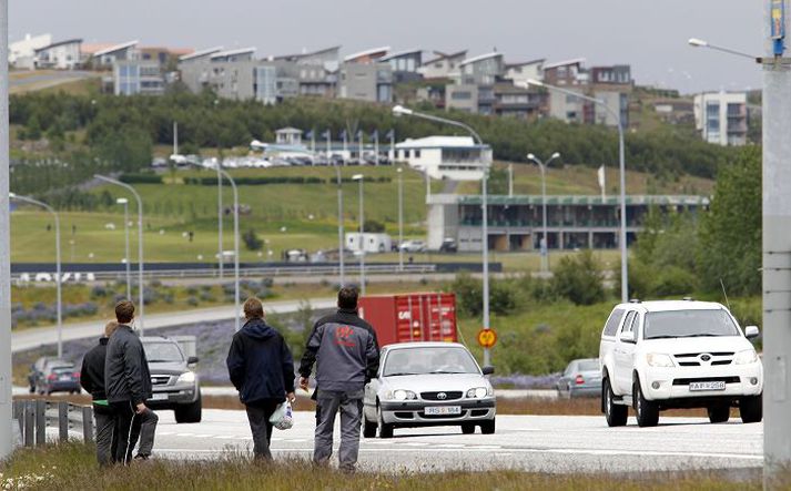 Á efri myndinni má sjá farþega bíða eftir vagni á biðstöðinni norðan Vesturlandsvegar. Þeir sem standa lengst til vinstri skýla sér fyrir umferðinni á bak við vegrið. Á neðri myndinni má sjá brekkuna sem farþegar þurfa að klífa til að komast í strætó.