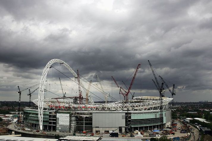 wembley Afhending nýja Wembley leikvangsins hefur dregist von úr viti. Leikvangurinn átti að vera tilbúinn í ágúst í fyrra en búist er við að afhendingin dragist fram á mitt næsta ár.