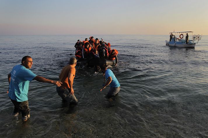 Grískir sjómenn aðstoða flóttafólk við að koma að landi á Lesbos í Grikklandi.