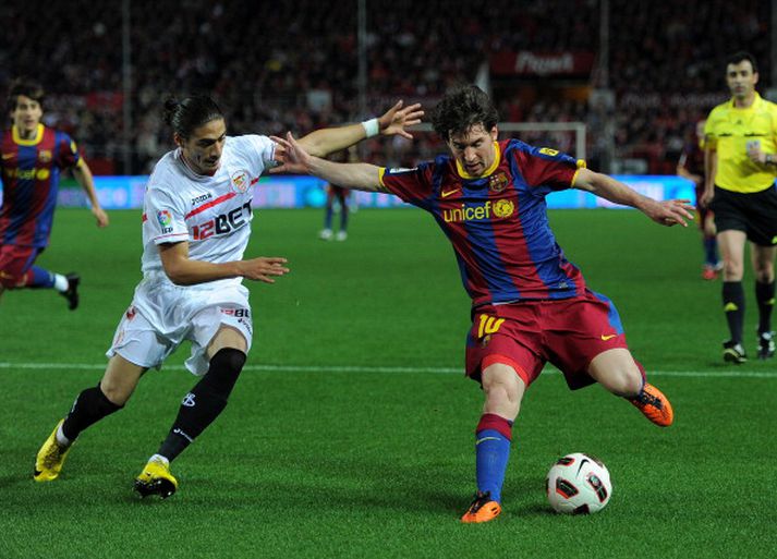 Lionel Messi í baráttunni við Jose Caceres leikmann Sevilla.