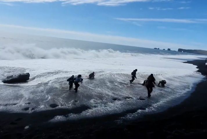 Turyści zaskoczeni przez falę na plaży Reynisfjara