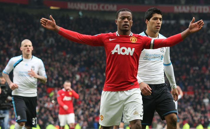 Patrice Evra fagnar sigri Man Utd á Liverpool fyrir framan Suarez.