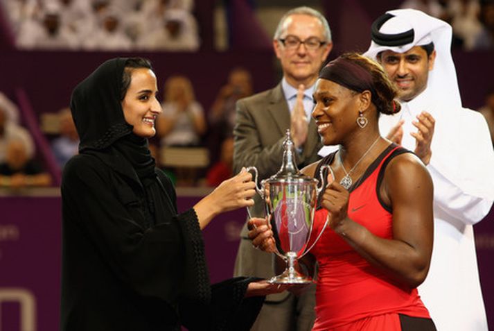 Serena Williams tekur á móti sigurlaununum í Doha í dag.