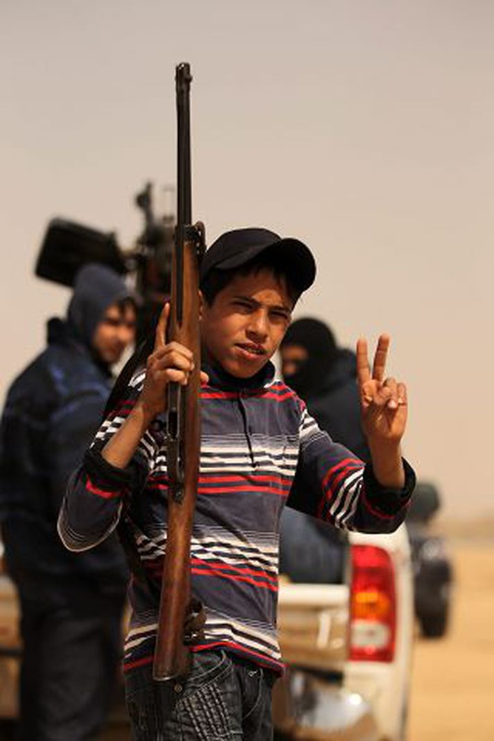 A Libyan youth holding a WWII Italian-made Beretta rifle flashes the victory sign in Ajdabiya on March 14, 2011 as Libyan strongman Moamer Kadhafi's forces shelled rebel positions on the doorstep of the key town which the revolution against his rule has vowed to defend at all costs. AFP PHOTO/PATRICK BAZ