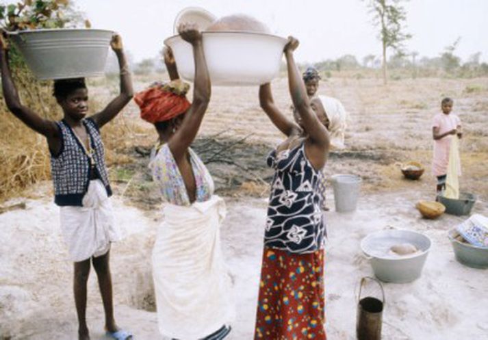 Konur sækja vatn í brunn í Guineu-Bissau.