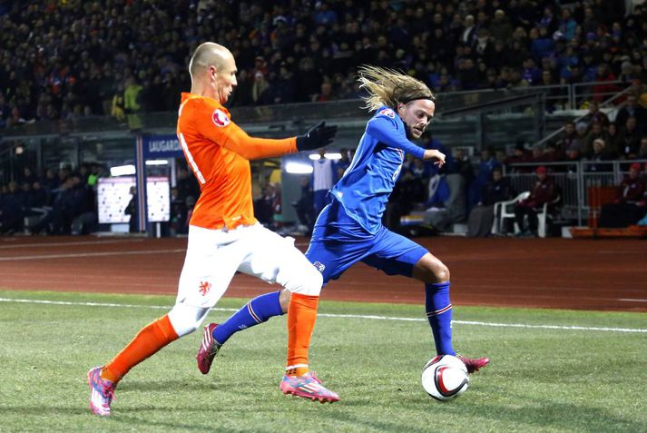 Birkir Bjarnason reynir að fara framhjá Arjen Robben í leiknum á mánudaginn.