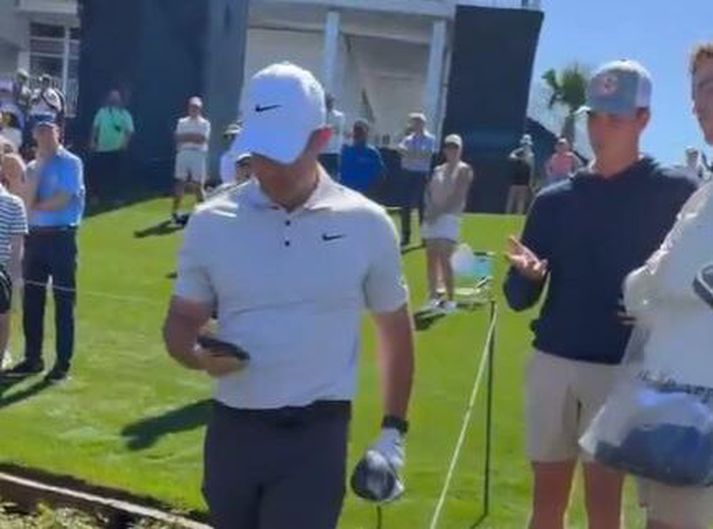 Rory McIlroy með símann sem hann tók af pirrandi áhorfanda.