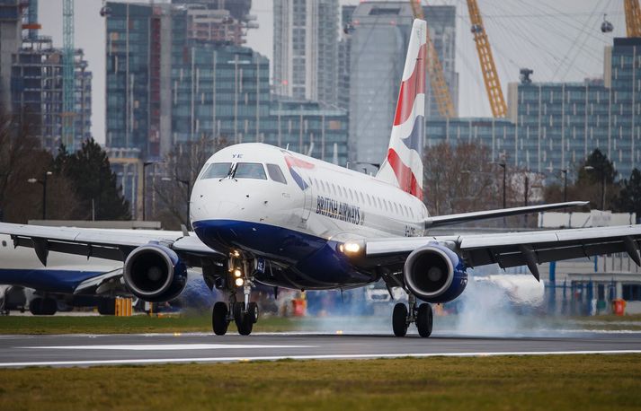 Þota British Airways lendir á London City-flugvellinum. Fjármálahverfið í baksýn.