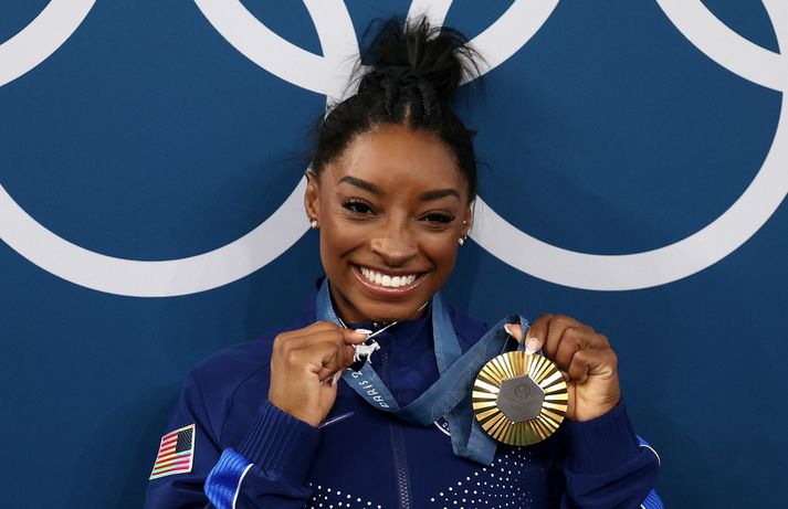 Simone Biles með gullverðlaunin og geitarhálsmenið.