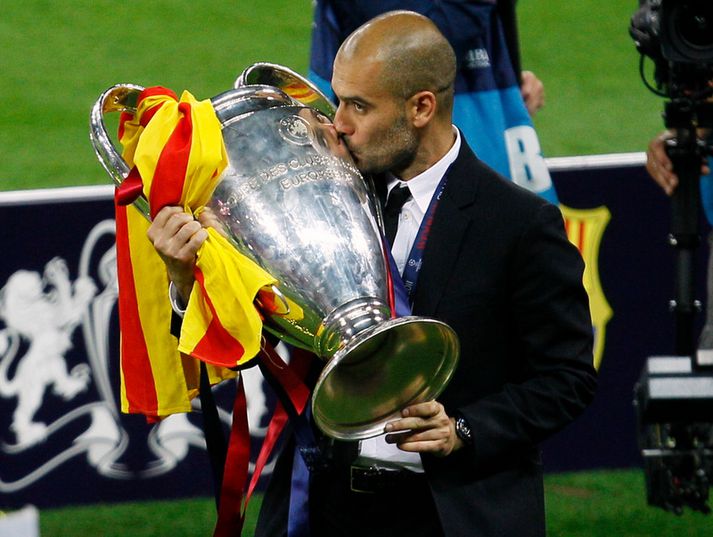 Pep Guardiola, þjálfari Barcelona, með Meistaradeildarbikarinn í kvöld.