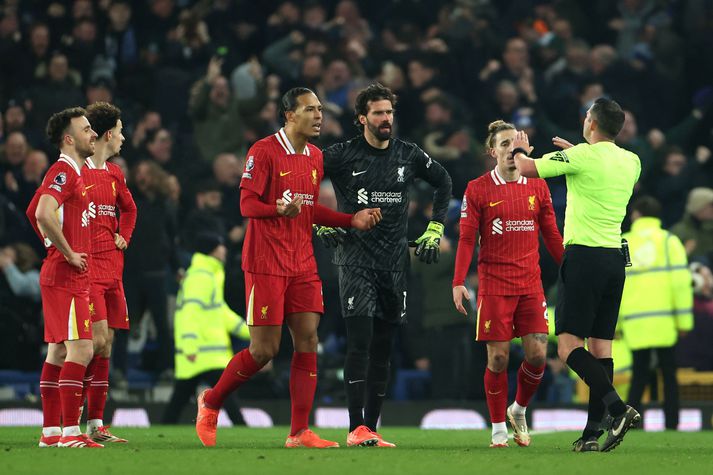 Michael Oliver dómari segir hér Virgil van Dijk og Alisson Becker að halda sér fjarri honum eftir að James Tarkowski skoraði jöfnunarmark Everton.