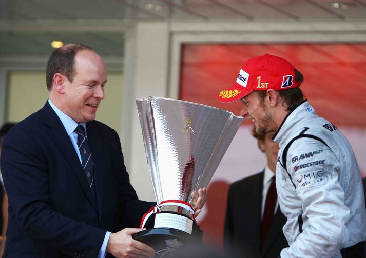 Albert prins í Mónakó afhendir Jenson Button sigurlaunin eftir öruggan sigur í dag.