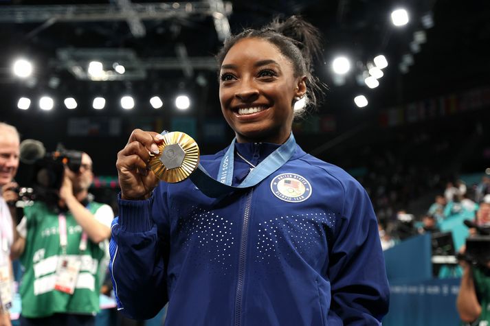 Simone Biles með gullmedalíuna sína.