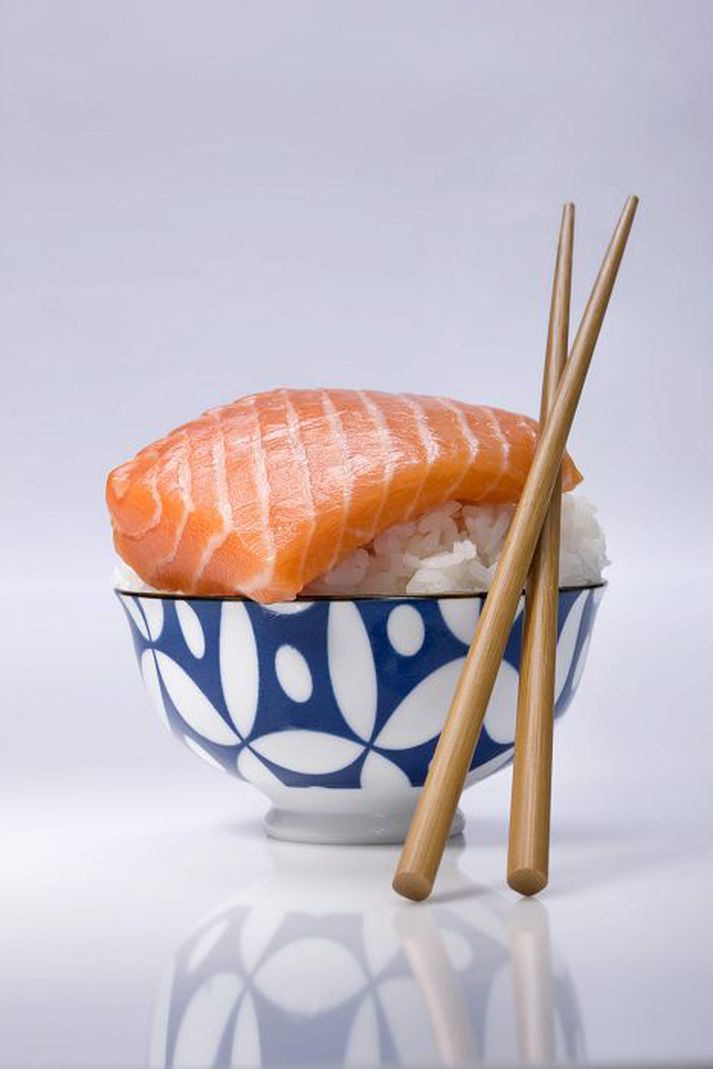 Bowl of sushi rice and piece of raw sal