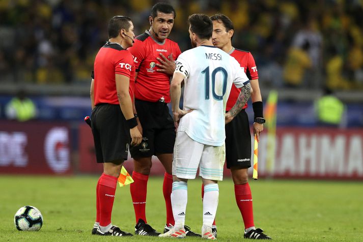Lionel Messi reynir að tala við ekvadorska dómarann og aðstoðarmenn hans.