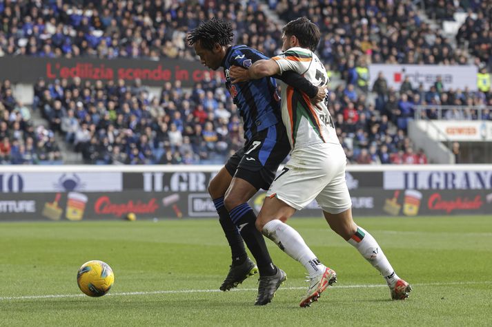 Mikael Egill Ellertsson í baráttu við Juan Cuadrado í leik Atalanta og Venezia í dag.