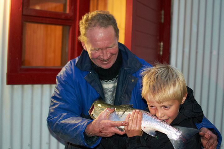 Hlynur Örn Arnarson bítur hér bakuggann af maruílaxinum og afi hans, Jón Guðmundsson, fylgist ánægður með.