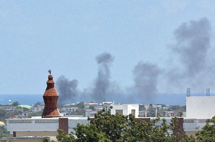 Reykur stígur upp frá flugvellinum þar sem þyrlan fórst.