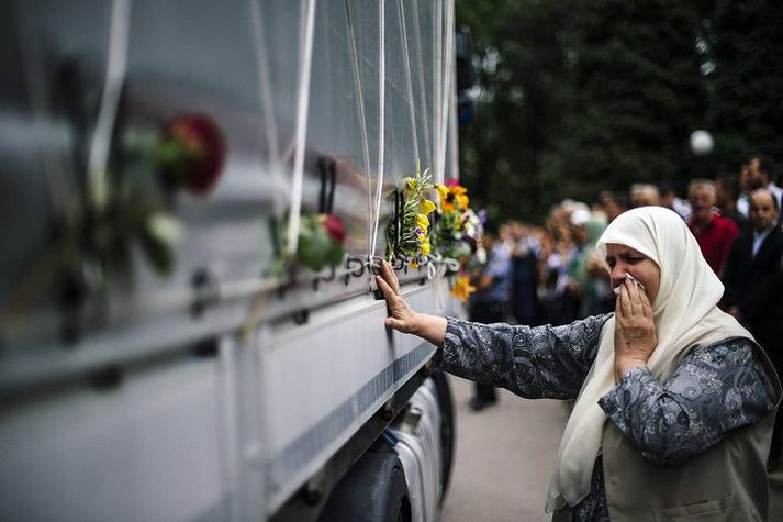 Fjöldi fólks safnaðist saman við flutningabíl sem flytur líkamsleifar fórnarlambanna til hinstu hvílu. 