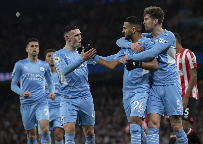 Riyad Mahrez er hér fagnað af liðsfélögum sínum Phil Foden og John Stones eftir að hafa skorað fyrir Manchester City á móti Brentford á Etihad leikvanginum.