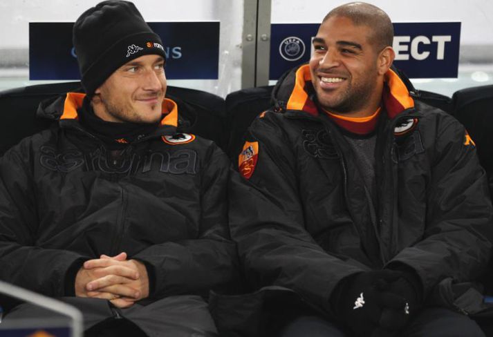 Adriano (til hægri) situr hér á bekknum með Francesco Totti.