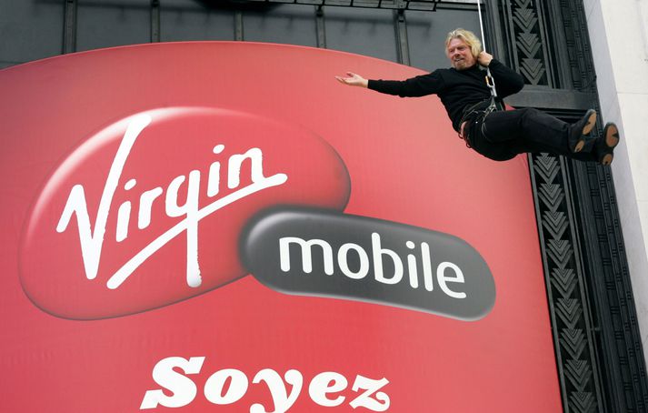 Richard Branson, stofnandi Virgin-keðjunnar, hangandi utan á húsnæði Virgin Mobile í París í Frakklandi á mánudag.