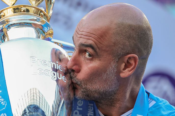 Pep Guardiola kyssir hér bikarinn eftir að Manchester City vann Englandsmeistaratitilinn fjórða árið í röð og í sjötta sinn undir hans stjórn. Hann hefur framlengt samning sinn þrátt fyrir að ekki sé búið að dæma í málinu.