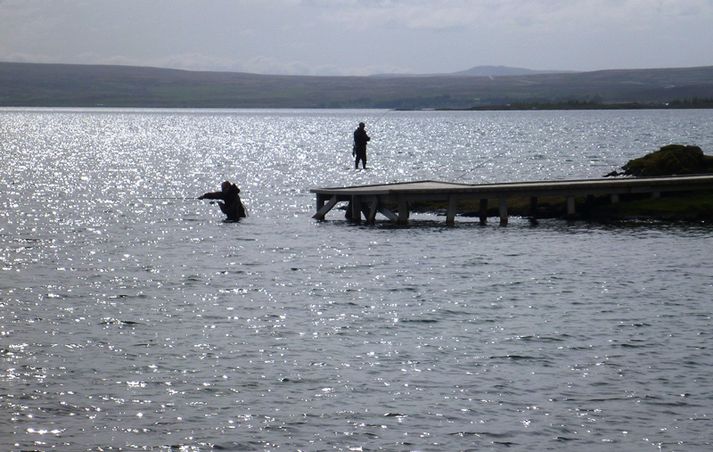 Í Vatnskoti í Þingvallavatni. Það er engu líkara en að annar þessara veiðimanna gangi á vatninu.