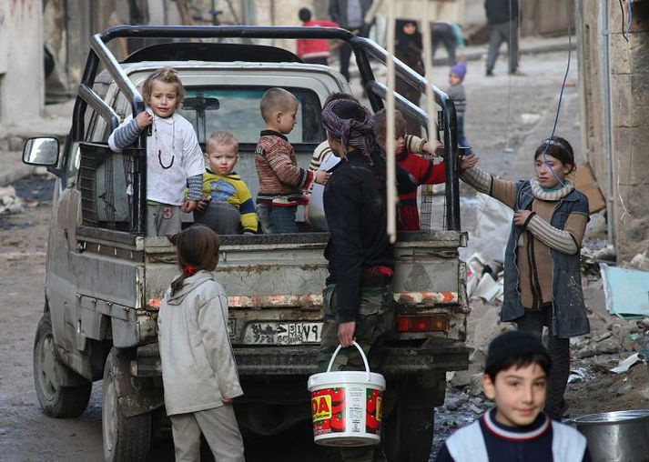 Börn í Aleppo flýja hverfið Bab al-Hadid eftir loftárásir í fyrrinótt.