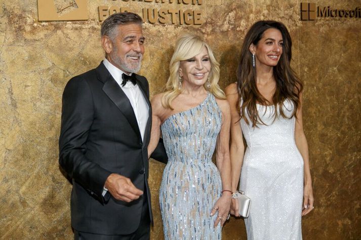 Donatella Versace fyrir miðju ásamt Clooney hjónunum George og Amal á góðgerðarviðburði þeirra í New York árið 2023.