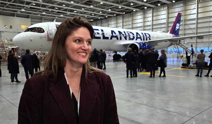 Sylvía Kristín Ólafsdóttir, framkvæmdastjóri flugrekstrarsviðs Icelandair, er kát með eldsneytissparnaðinn sem fylgir nýju flugvélinni fyrir aftan.