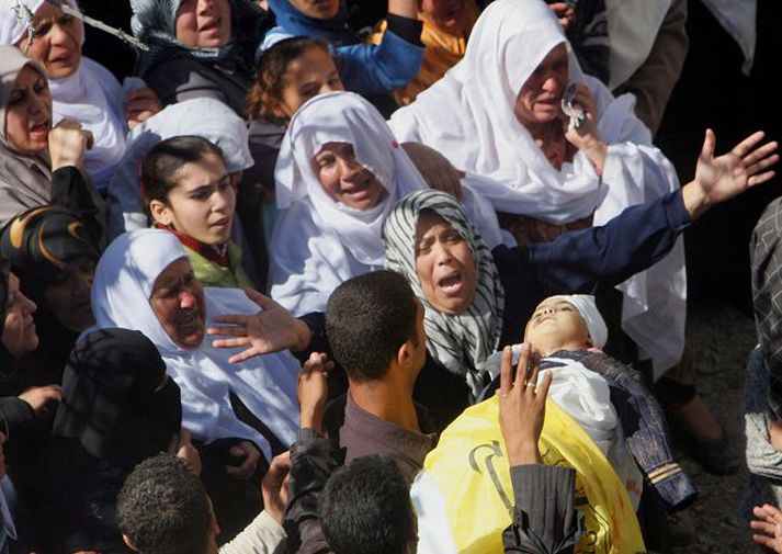 Þriggja ára stúlka borin til grafar á Gaza-svæðinu í gær Mörg þúsund Gaza-búar fylgdu til grafar þeim átján sem létust í árásinni. Þessar konur grétu sáran þegar líkin fóru hjá og kröfðust hefnda.