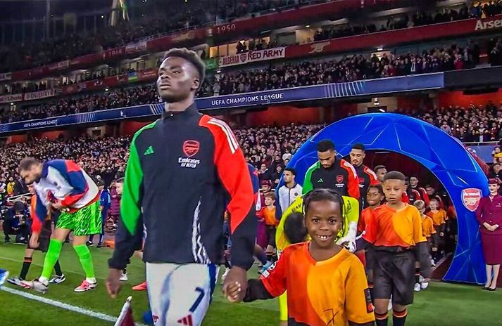 Bukayo Saka leiðir Thiago Sterling inn á Emirates völlinn.