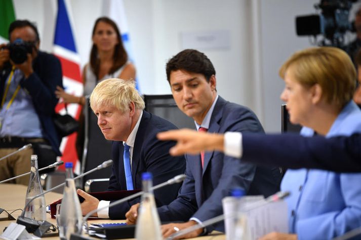 Johnson og Merkel með Justin Trudeau, forsætisráðherra Kanada, á milli sín á G7-fundi fyrr á þessu ári.