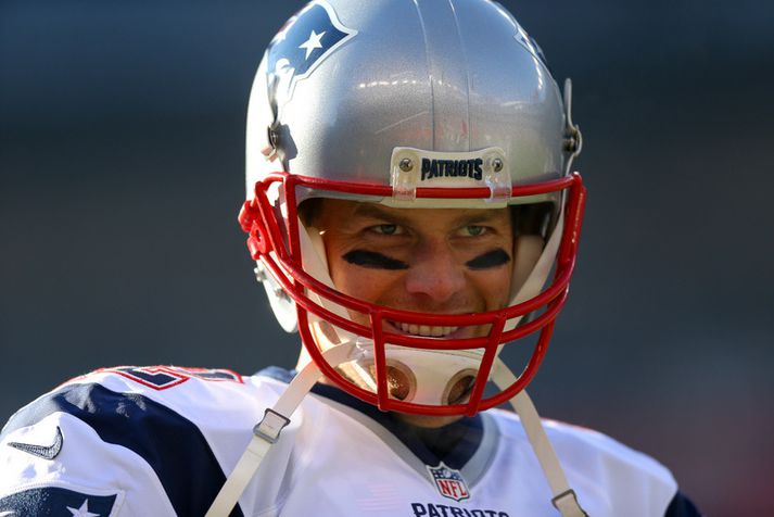 Tom Brady gat leyft sér að brosa í kuldanum í New England í gær.