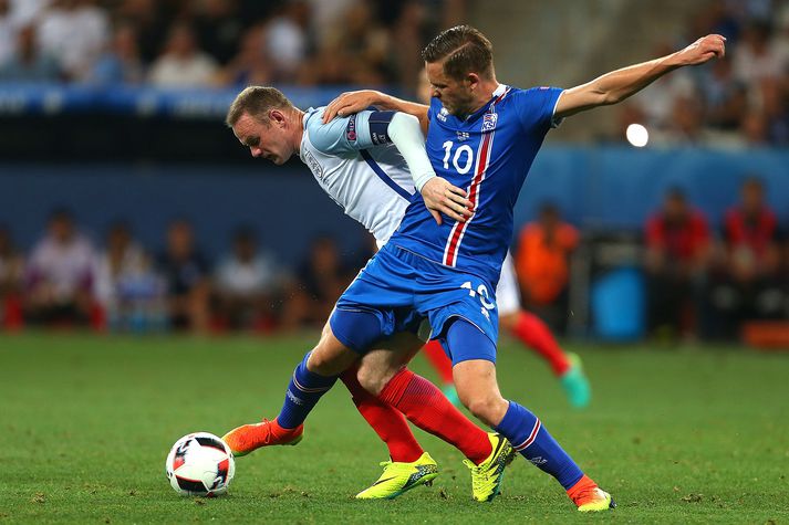 Gylfi í baráttunni gegn Wayne Rooney í Nice í sumar.