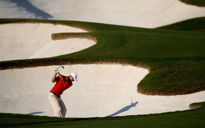 Martin Kaymer slær úr glompu í Dubai í dag.