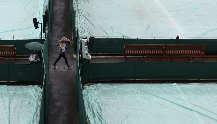 Dregið var yfir vellina á Wimbledon-svæðinu í gær vegna rigningar.