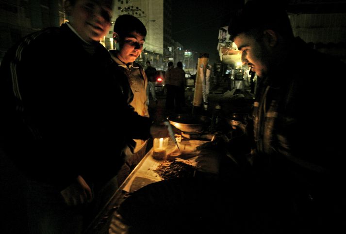 Kaupmenn á Gaza ströndinni selja fátæklegan varning sinn við kertaljós eða gasluktir.