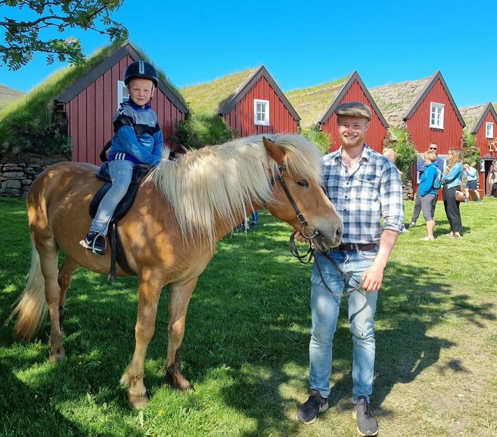 Eyþór Bragi Bragason, umsjónarmaður á Bustarfelli hér með hest og ungan knapa á baki við torfbæinn fallega.