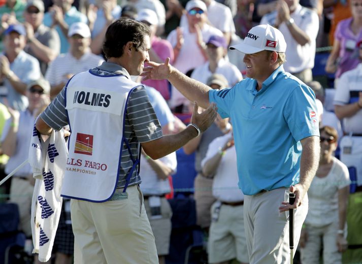 J.B. Holmes fagnar með kylfusveini sínum í kvöld.