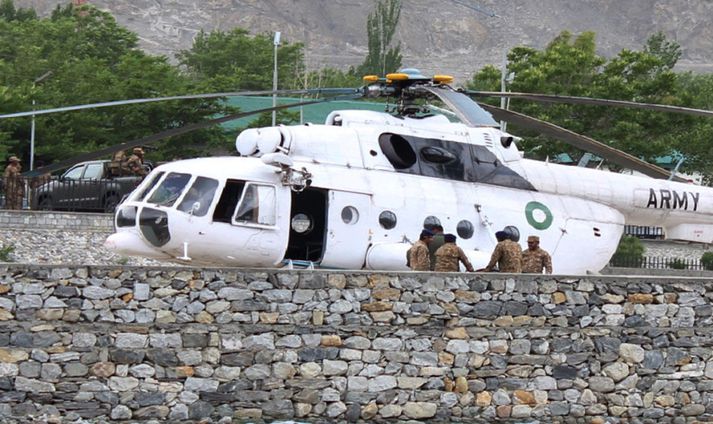 Pakistanskir hermenn standa vörð við þyrlu sem notuð var til að flytja slasaða á sjúkrahús.