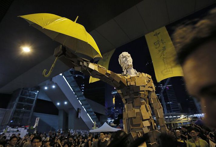 Stytta sem stúdentar bjuggu til heldur á gulri regnhlíf fyrir utan stjórnarbyggingu í Hong Kong. Stjórnvöld hafa krafist þess að lýðræðissinnar rými göturnar. 