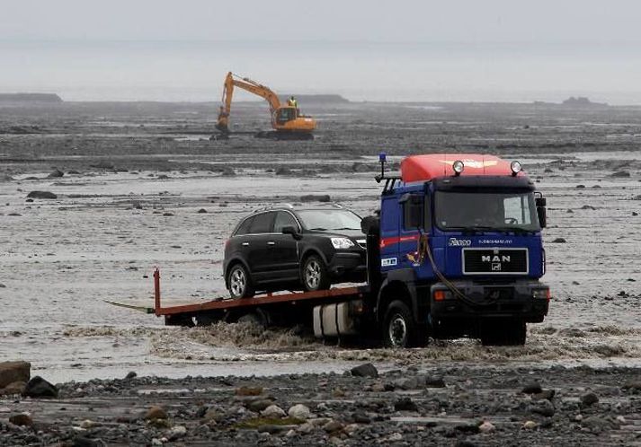 Þegar brúin verður tilbúin þurfa trukkar ekki lengur að flytja fólk yfir fljótið